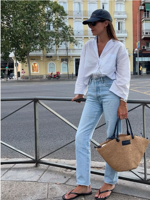 Chic summer outfit featuring light blue wide-leg jeans and minimalist leather flip-flops